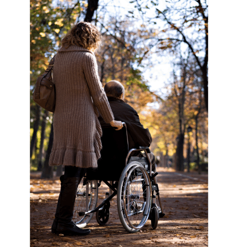 women pushing a man in manual wheelchair